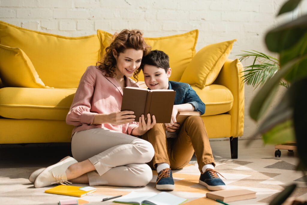 mother and son homeschooling reading a book together