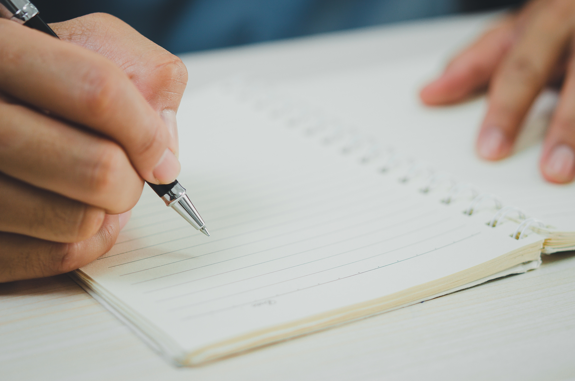 person holding a pen writing a school deregistration letter